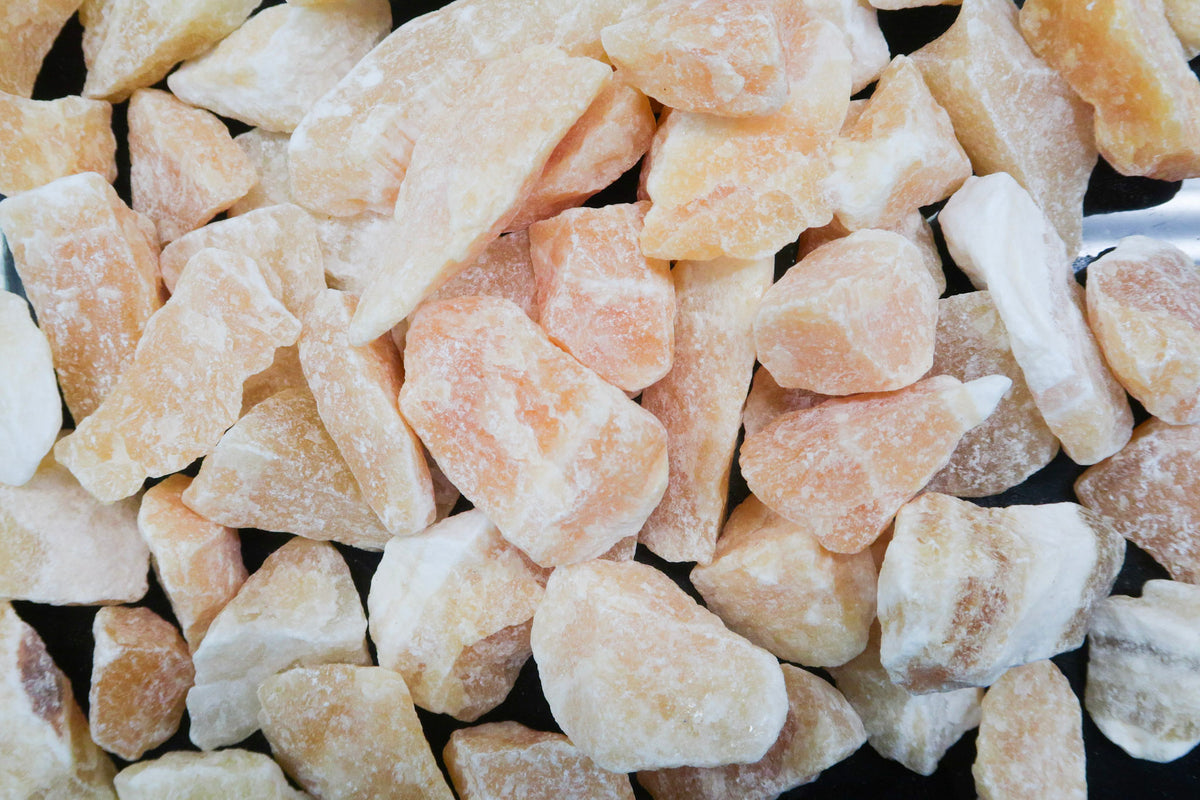A close up picture of rough orange calcite pieces. They are approximately 1 inch in size