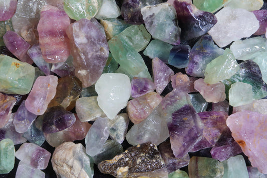 Close up picture of rough mexican rainbow fluorite stones that are approximately 1/2 inch to 1 inch in size.